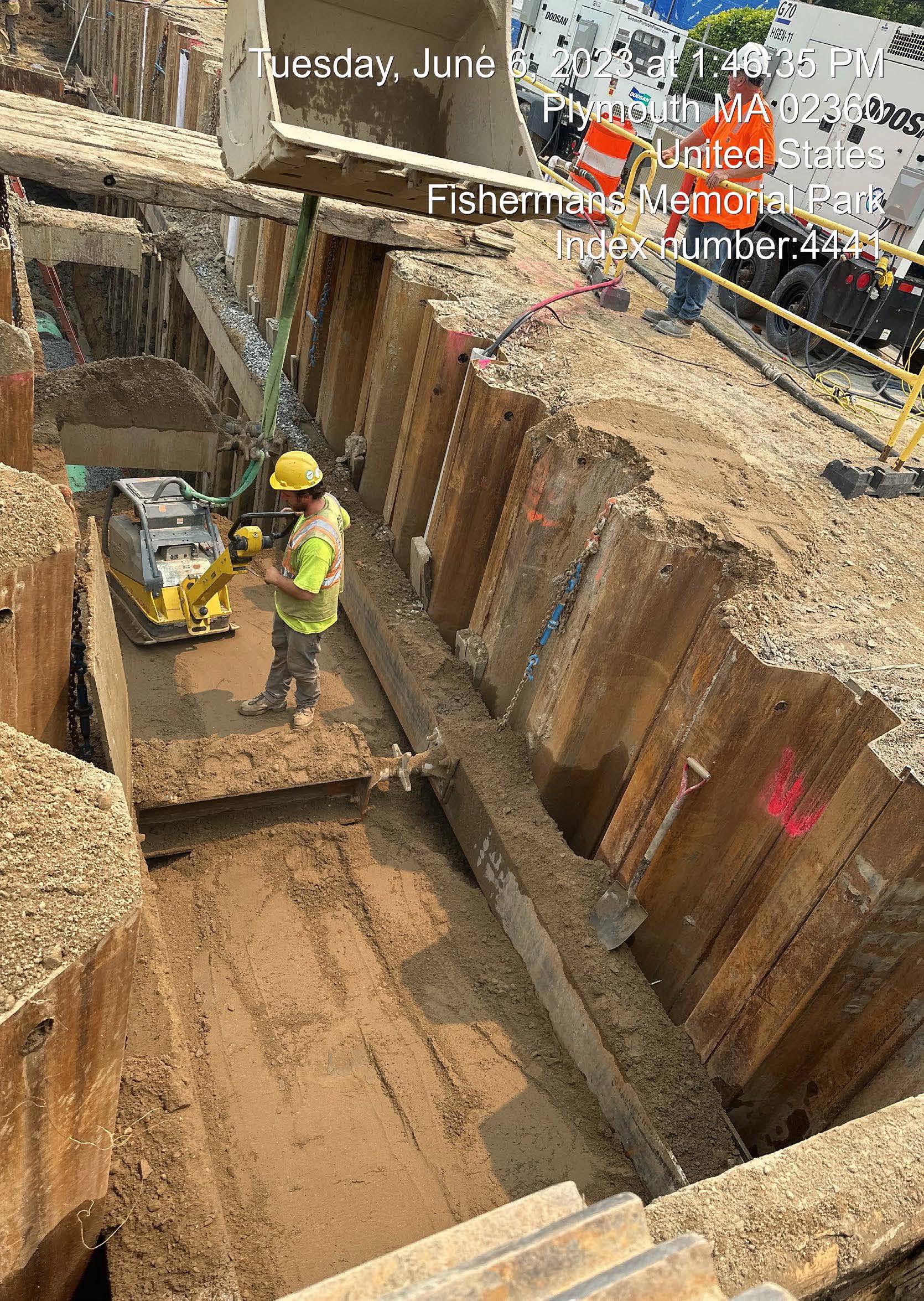 crew compacting sewer trench on Water Street